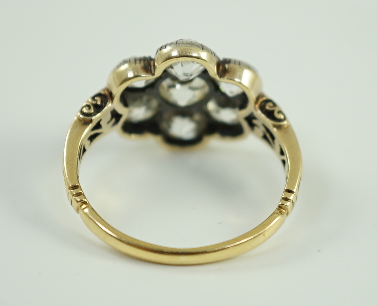 A late 19th/early 20th century gold and collet set seven stone old round cut diamond flower head cluster ring